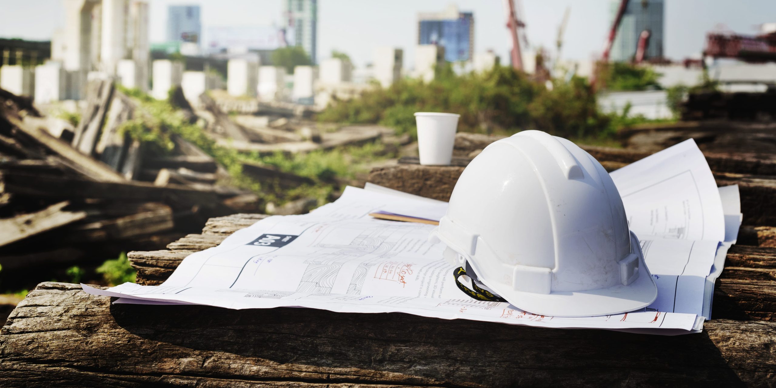 Casque de chantier posé sur des plans, illustrant les travaux en site occupé